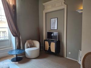 Una sala de estar con una silla y un televisor. en The Cozy 42 stylish apartment, en Carcassonne
