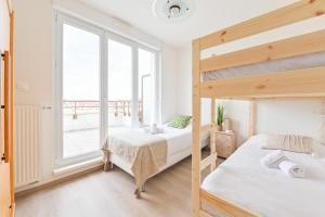 a bedroom with two bunk beds and a large window at L'équinox in Bourgheim