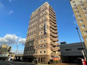 a tall building with balconies on the side of it at Hotel Route-Inn Fukui Ekimae in Fukui