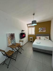 a bedroom with a bed and a table and chairs at מגדל חי 1 in Eilat
