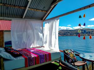 a bed on a porch with a view of the water at Sol del Titikaka Lodge in Puno +14 photos
