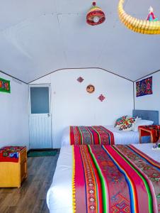 a room with two beds with colorful blankets at Sol del Titikaka Lodge in Puno