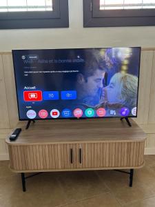 a flat screen tv sitting on top of a wooden stand at Maison loft au cachet ancien in Villasavary