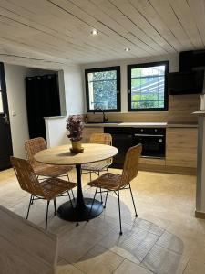 a kitchen with a table and chairs in a room at Maison loft au cachet ancien in Villasavary