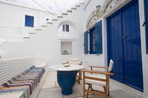 un patio con mesa y sillas y una puerta azul en Ioanna's, en Pánormos