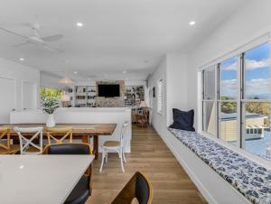 Sala de estar y comedor con sofá y mesa en High Tide 4BR 3 level house Ocean views & Pool, en Kingscliff