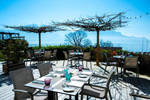 a group of tables and chairs in a patio at Pavillon Bon Rivage in La Tour-de-Peilz