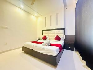 a bedroom with a large bed with red pillows at WooibHotels Yogasthali Tapovan in Rishīkesh
