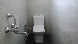 a bathroom with a white toilet in a stall at Sayatri stay in Karsiyang