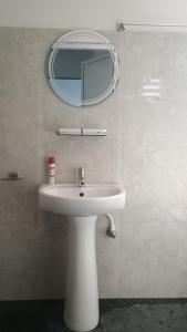 a bathroom with a white sink and a mirror at Sayatri stay in Karsiyang