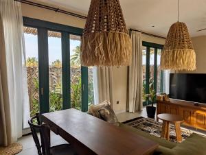 a living room with a table and a television at LAWA Bintan Berakit Village Cottage in Berakit
