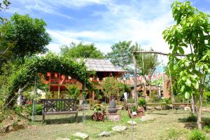 a garden with a house in the background at The Bare Nest Retreat in Làng Lai