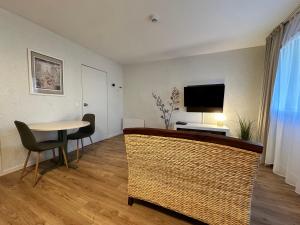 a living room with a table and a television at Hotel Chantereyne in Cherbourg en Cotentin
