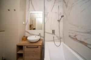 a white bathroom with a sink and a shower at Maya's Flats & Resorts 30 - 3 pokojowy apartment n in Gdańsk +38 photos