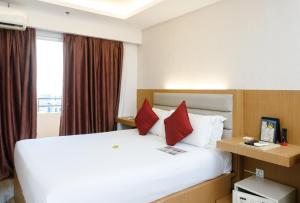 a hotel room with a large bed with red pillows at LivStudios Manila Bay in Manila +26 photos
