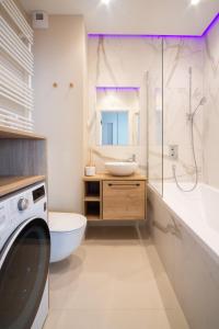 a bathroom with a sink and a washing machine at Maya's Flats & Resorts 30 - 3 pokojowy apartment n in Gdańsk