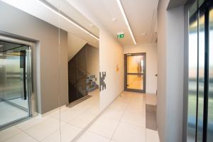 a hallway with glass doors in a building at Maya's Flats & Resorts 30 - 3 pokojowy apartment n in Gdańsk