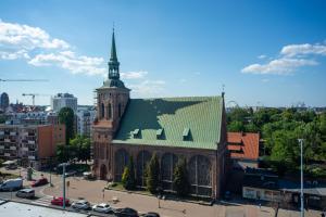 a large building with a tower with a green roof at Maya's Flats & Resorts 30 - 3 pokojowy apartment n in Gdańsk