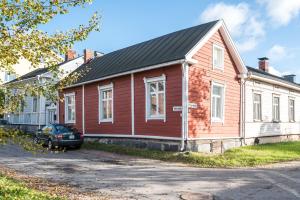 a red house with a car parked in front of it at Hirsihuvi 1826 in Oulu