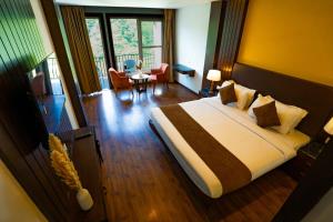 Una habitación de hotel con una cama, una mesa y sillas. en Hotel White Flower, en Jāmb