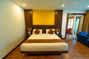 Un dormitorio con una cama grande y un sofá azul en Hotel White Flower, en Jāmb