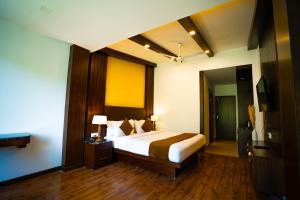 Una habitación de hotel con una cama y un televisor. en Hotel White Flower, en Jāmb