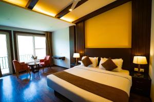 Una habitación de hotel con una cama, una mesa y sillas. en Hotel White Flower, en Jāmb