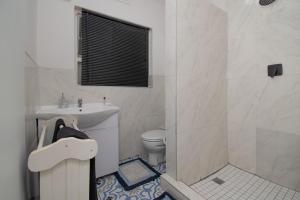 ダーバンにあるNo 20 On the Beach Guesthouseの洗面台、トイレ、シャワー付きのバスルーム