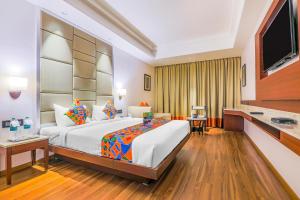 a hotel room with a bed and a flat screen tv at FabHotel Golden Vista in Bengaluru +20 photos