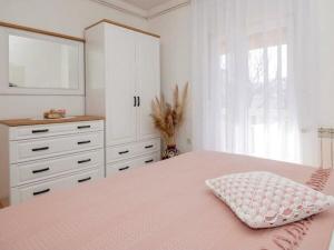 a bedroom with a pink bed and a dresser at Stella with pool & heated jacuzzi in Zmijavci +40 photos