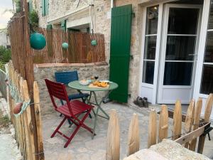 a patio with a table and chairs and a door at La maison du pêcheur in Dolus d'Oléron