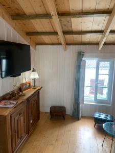 a living room with a flat screen tv and a window at La maison du pêcheur in Dolus d'Oléron