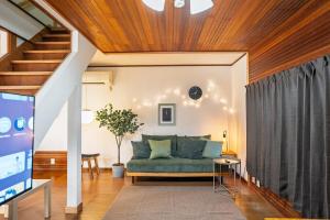 ein Wohnzimmer mit einer Couch und einer Treppe in der Unterkunft R-house 6th in Atami