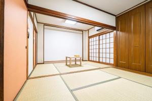ein leeres Zimmer mit einem Tisch und einem großen Fenster in der Unterkunft R-house 6th in Atami