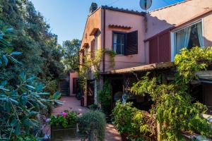 une maison ancienne avec un jardin en face dans l'établissement Villa Luce, à Porto Santo Stefano