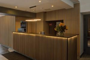 a lobby with a counter with a vase of flowers at Waldhotel Wandlitz in Wandlitz