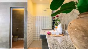 La salle de bains est pourvue d'un comptoir orné de fleurs. dans l'établissement Indochine Sanctuary Hotel, à Phumĭ Ta Phŭl