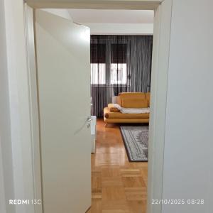 an open door to a living room with a couch at FushKosov in Kosovo Polje