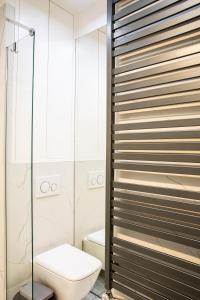 Un baño con inodoro y ducha de cristal. en Maya's Flats & Resorts 44 - 3 Rooms Apartment On C, en Gdansk