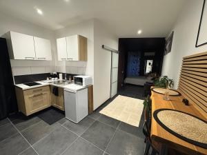 a kitchen with white cabinets and a table and a kitchen with a tableablish at Appartement Romantique Exceptionnel in Lorette
