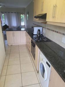 a kitchen with a washer and dryer on the counter at Franjipani in Margate