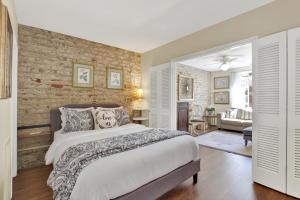 a bedroom with a bed and a brick wall at Above the Tea Room off Madison Square in Savannah +33 photos