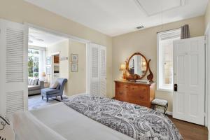 a bedroom with a bed and a mirror and a chair at Above the Tea Room off Madison Square in Savannah +22 photos