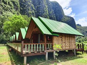 a small wooden house with a green roof at Namnoncave Resort in Ban Namnon