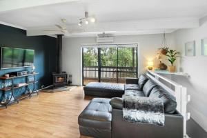 a living room with a couch and a television at Lakeview Retreat Bonnie Doon - Sleeps 12 in Bonnie Doon