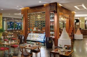 a restaurant with tables and chairs and wine bottles at Sokha Phnom Penh Residence in Phnom Penh