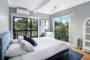 a bedroom with a large white bed and a balcony at Lakeview Retreat Bonnie Doon - Sleeps 12 in Bonnie Doon