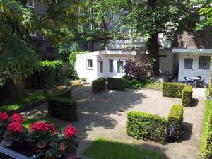 a garden with bushes and flowers in front of a building at Hotel Alexander in Amsterdam