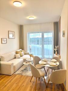 a living room with a couch and a table and chairs at apartino - FREE parking - Novostavba - Omezený přístup a stavební ruch - New Building - Limited Access and Construction noise in Komárov
