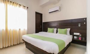 a bedroom with a large bed with green pillows at FabHotel Red Ark Inn in Lāndrān +16 photos